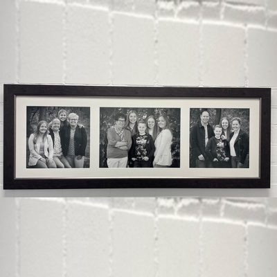 Drie zwart-witte familiefoto’s naast elkaar in één brede donkere lijst met passe-partout