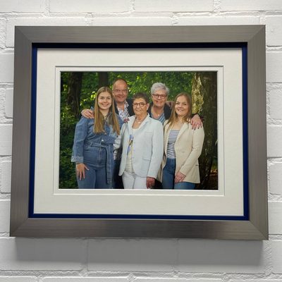 Familieportret in kleur met dubbele passe-partout en blauwe binnenlijst in een geborsteld zilveren lijst