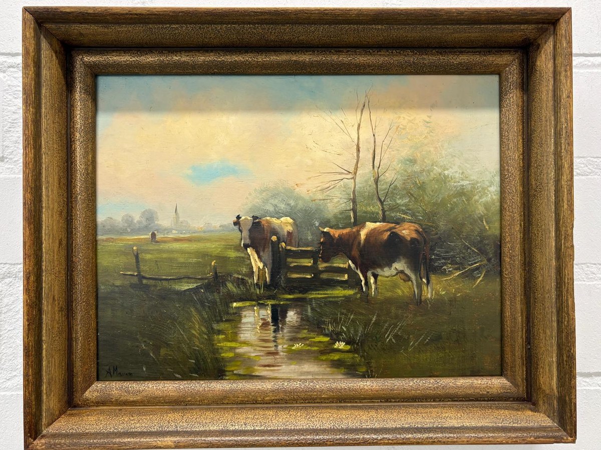 Hetzelfde koeienschilderij na reiniging en nieuwe slotvernis, in een houten lijst aan de muur